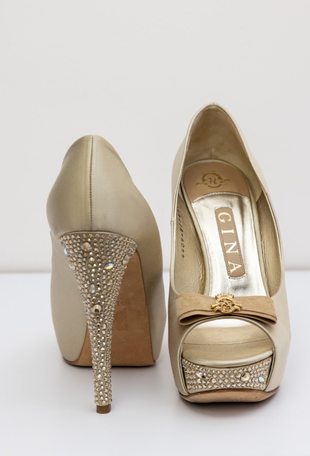 Gina Golden satin pumps with embellished crystal heel and platform, front bow with gold logo