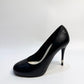 CHANEL black leather pumps with a pearl-embellished heel, highlighting the elegant curve and premium craftsmanship.