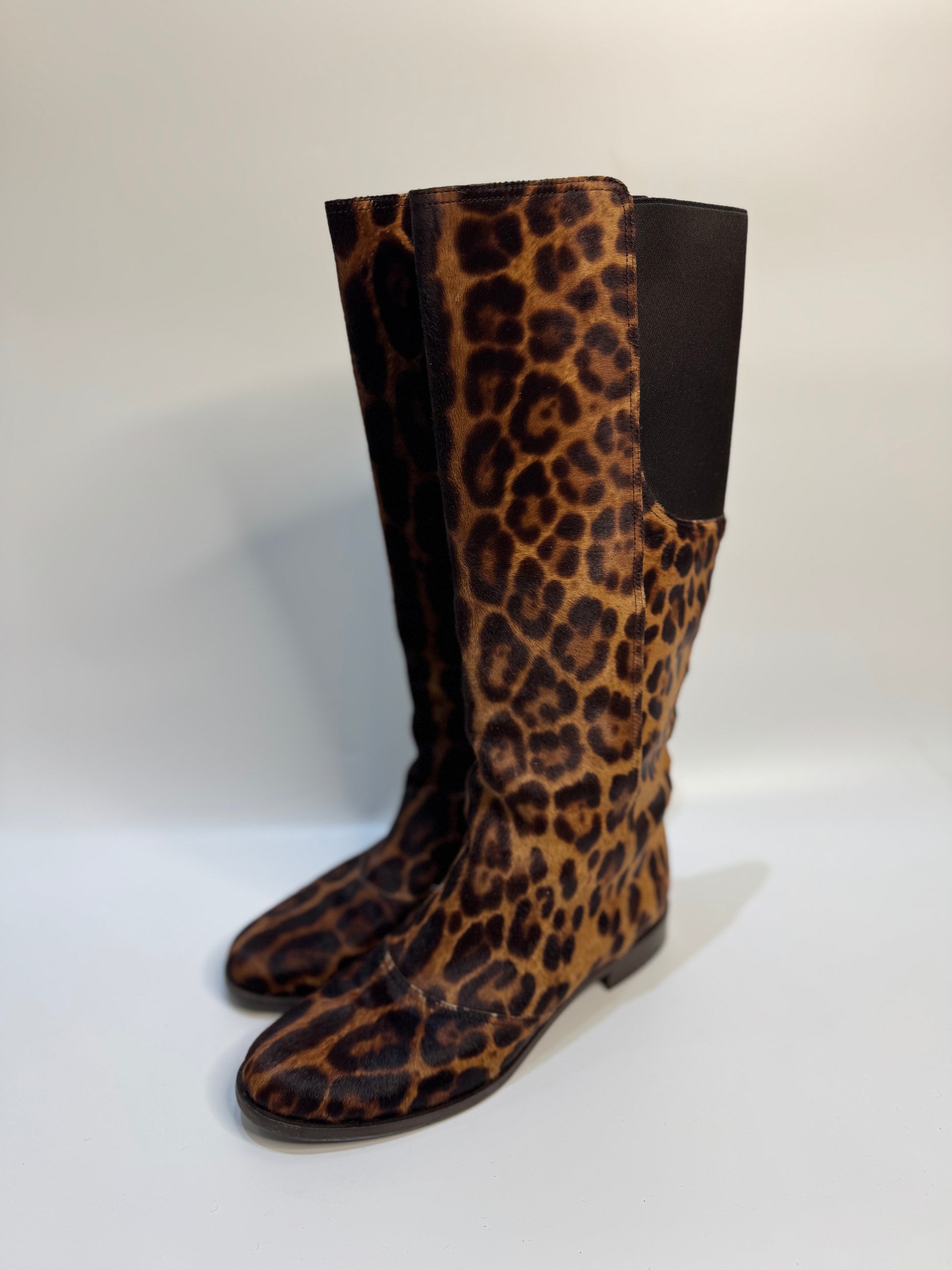 Side angle of the leopard print boots, highlighting the soft calf hair texture and knee-high design.