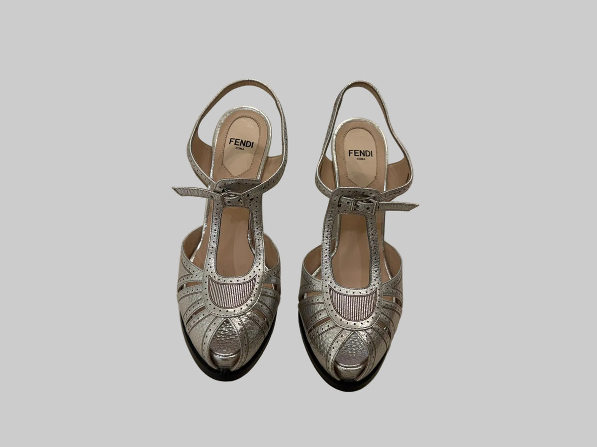 A pair of Fendi metallic silver slingback high-heeled sandals with cutout detailing and ankle straps.