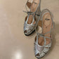 A pair of Fendi metallic silver strappy sandals with cutout details and ankle straps.