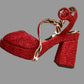 Red high-heeled shoe charm on a beige background