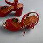 Red high-heeled shoes with leopard print insides on a light surface