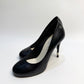 CHANEL black leather pumps with a pearl-embellished heel, highlighting the elegant curve and premium craftsmanship.