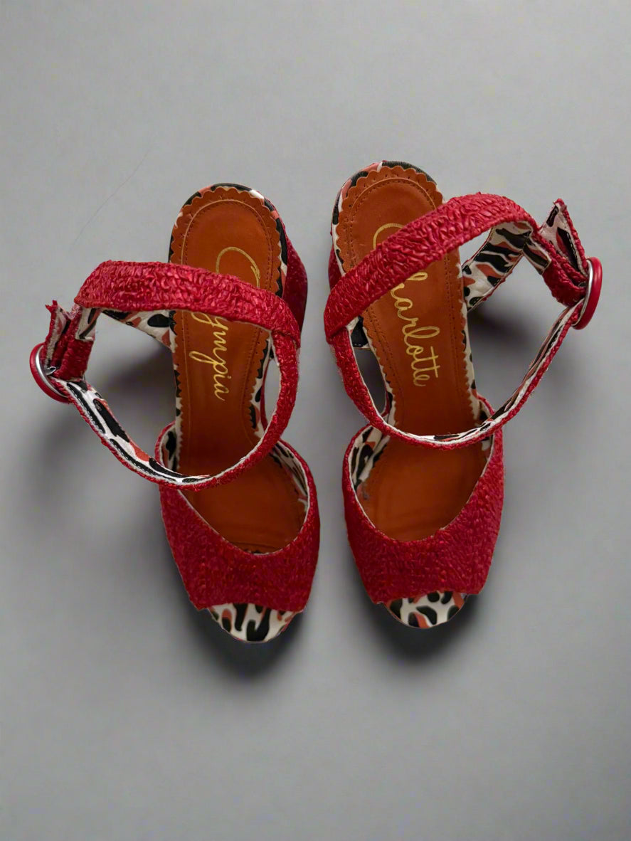 Red sandals with patterned straps on a light background