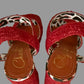 Red sandals with leopard print straps on a light background
