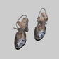 A pair of Fendi metallic silver slingback high heels with cutout detailing and T-strap bows.