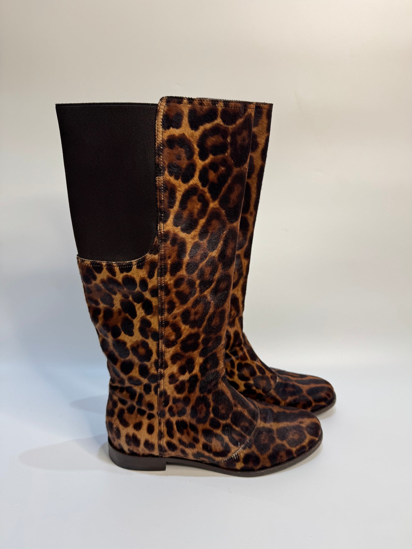 Side angle of the leopard print boots, highlighting the soft calf hair texture and knee-high design.