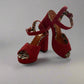 Red high-heeled shoes with leopard print accents on a reflective surface.