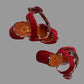 Red sandals with leopard print straps on a beige surface