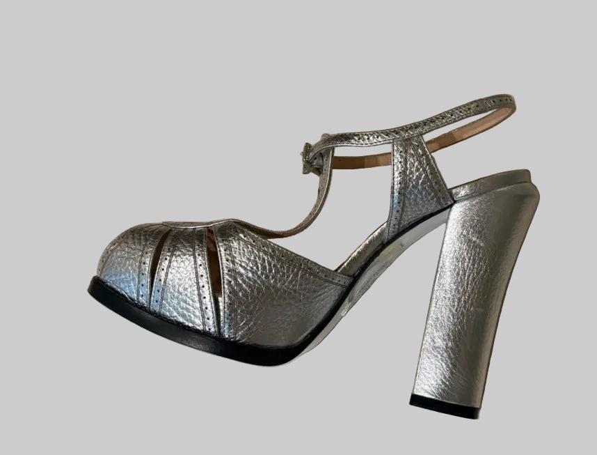 A pair of metallic silver high-heeled sandals with a block heel and strappy design.